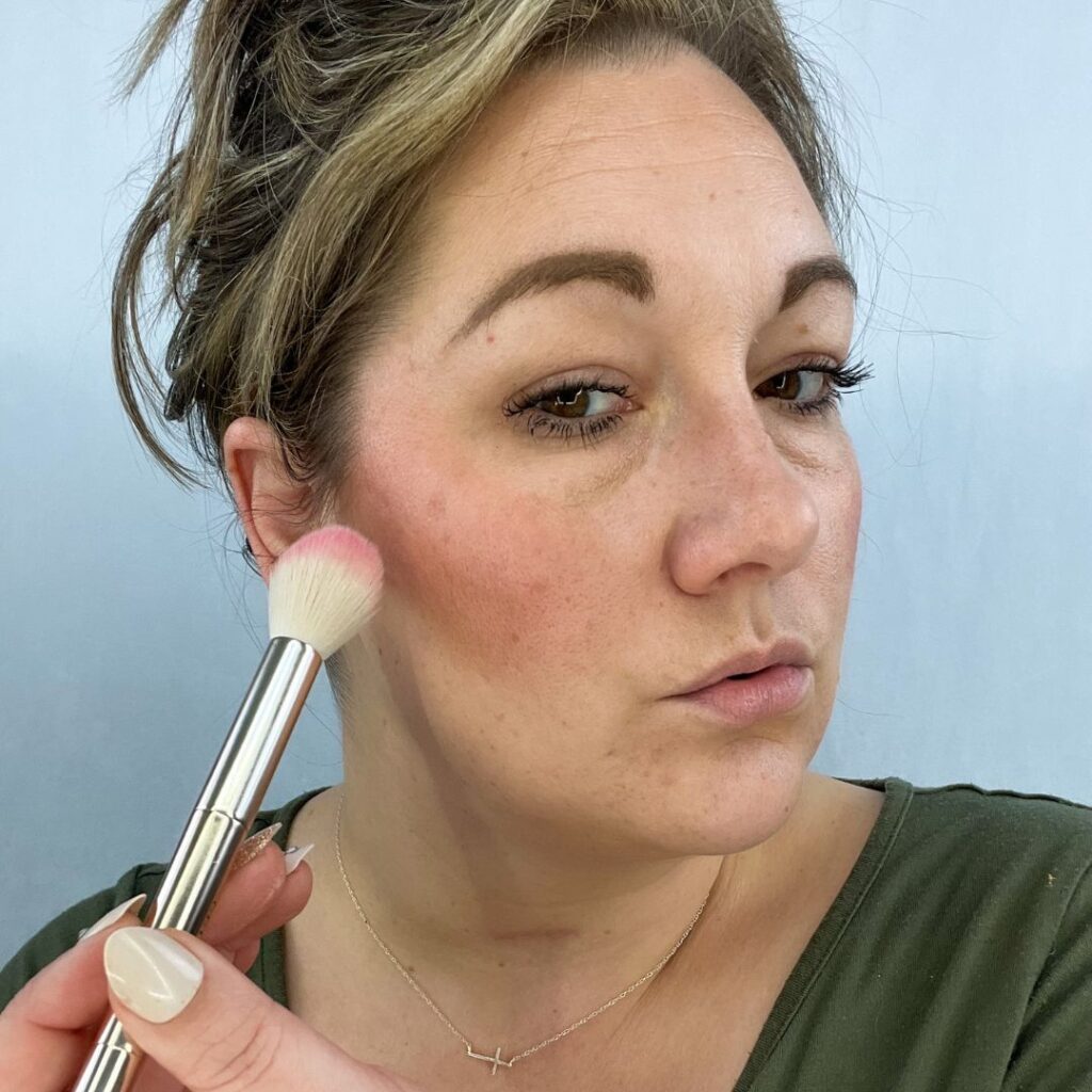 me using the blend brush to add cheek color